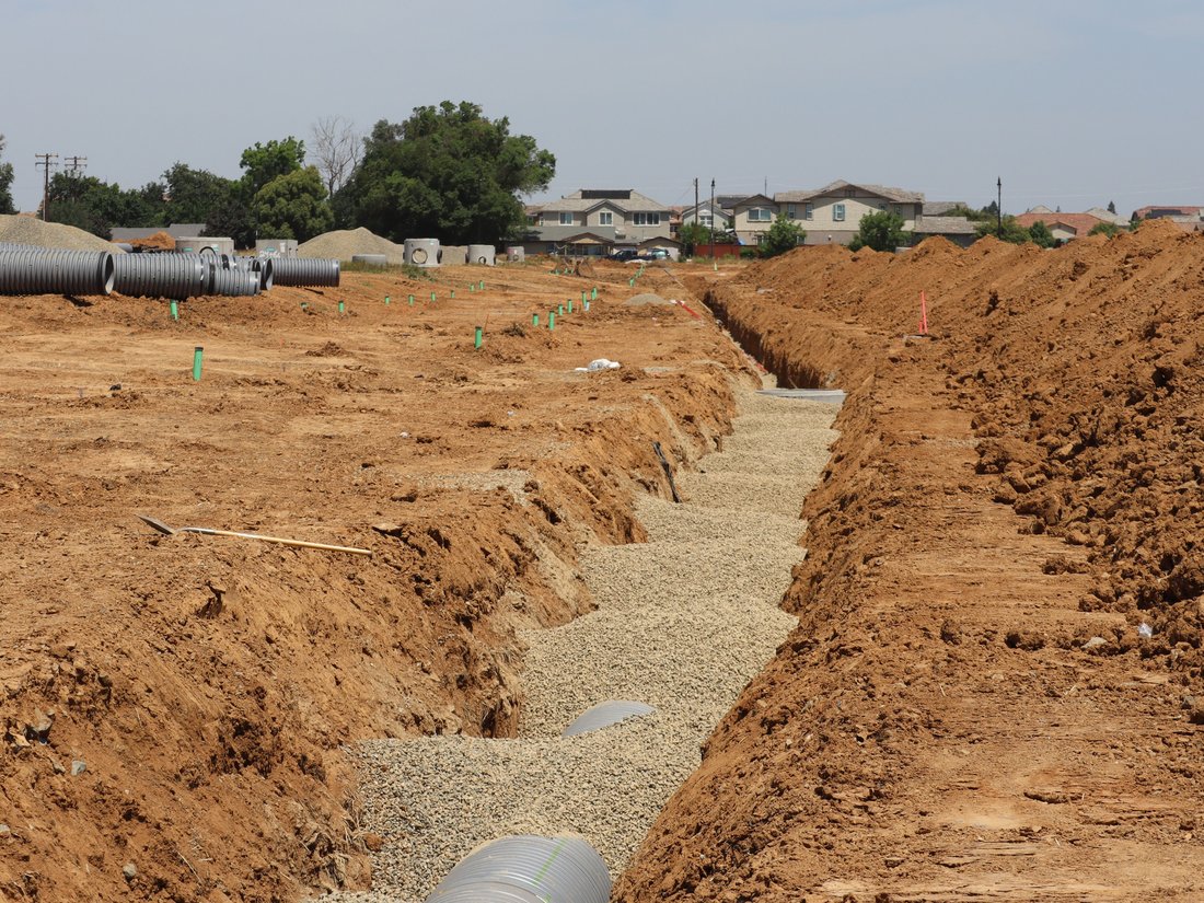 Wide excavated trench at a residential construction site